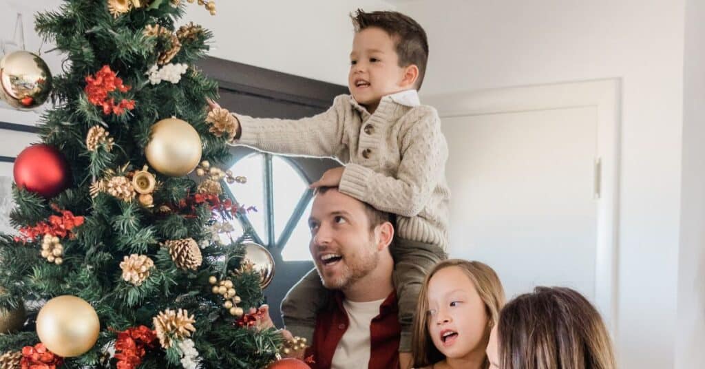 A family decorates their Christmas tree together during the holidays