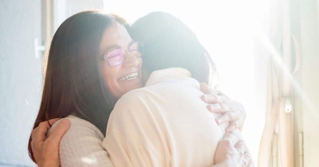 Two people happily embrace in bright sunlight